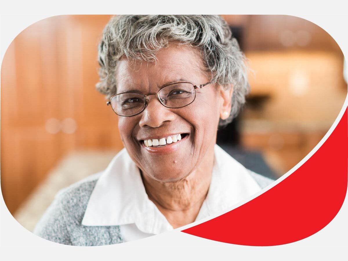 Neatly dressed elderly woman smiling at home